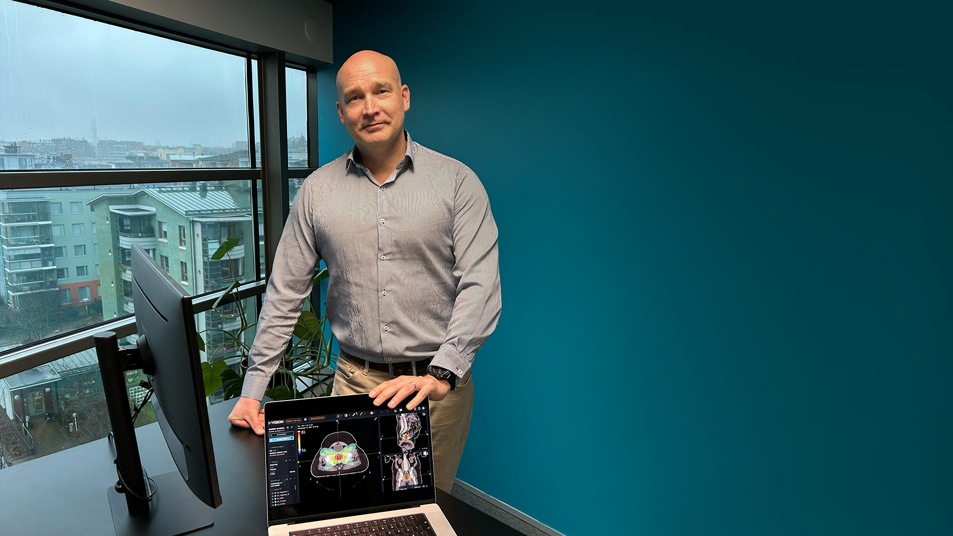Dr. Kiljunen standing at a desk, hands placed on a laptop